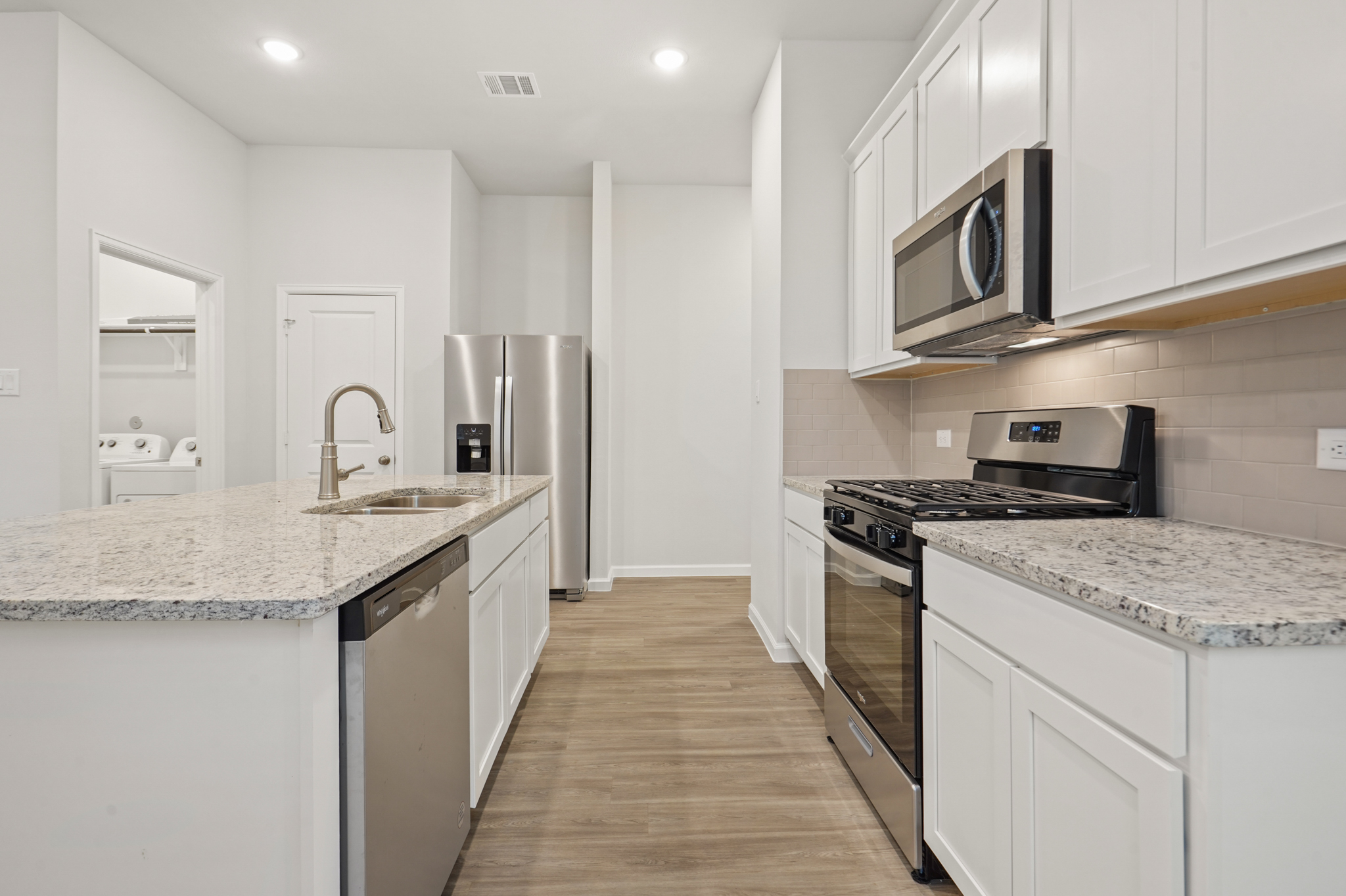 A kitchen with white cabinets.