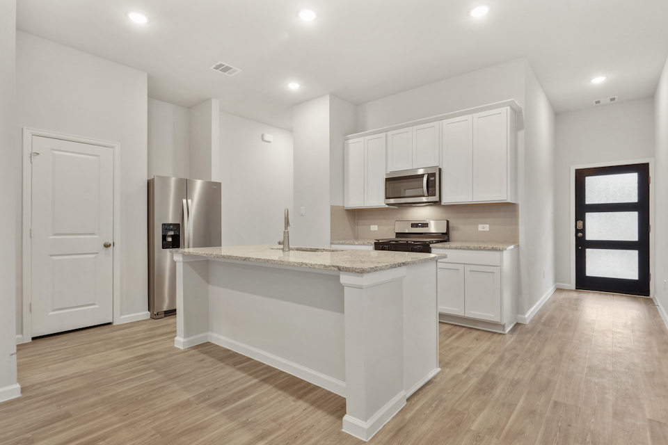 A kitchen with white cabinets.