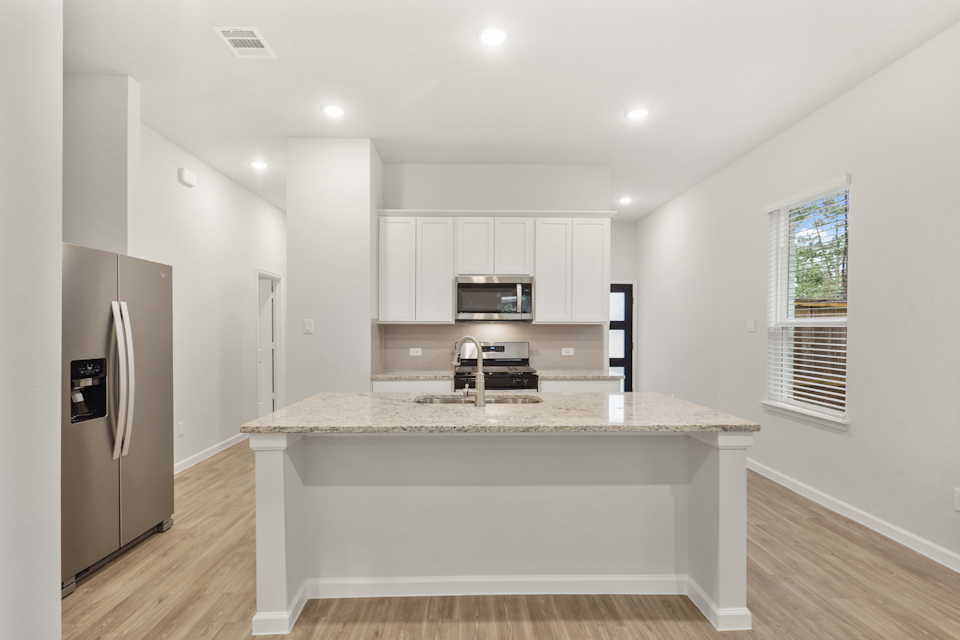 A kitchen with white cabinets.