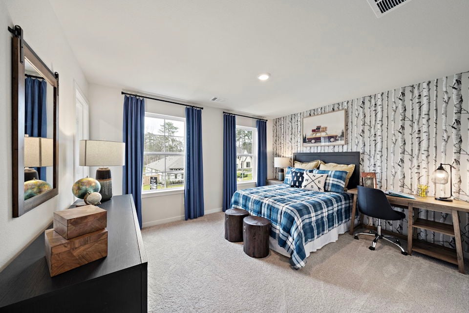 A bedroom with a bed and a desk.