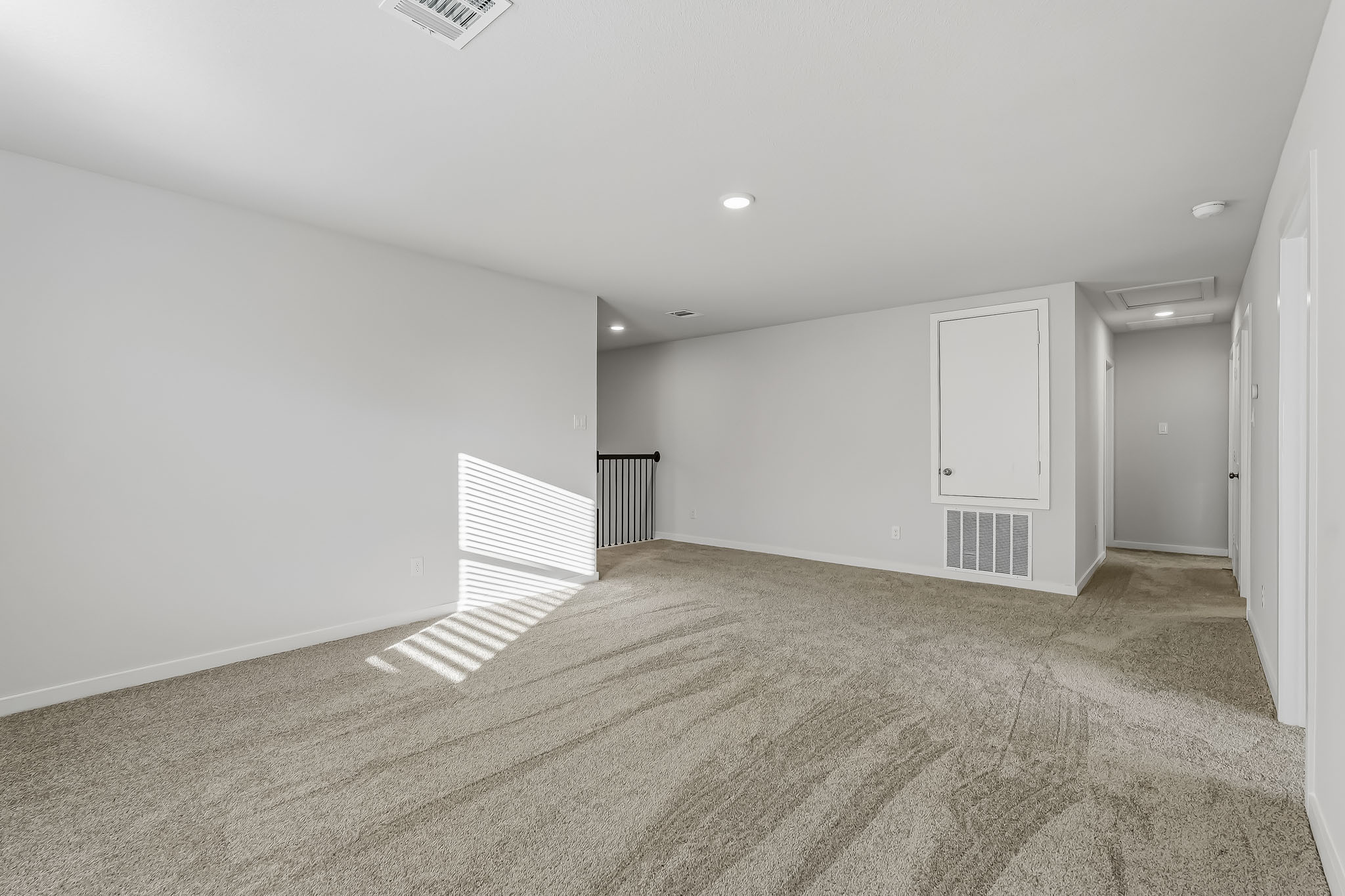 A room with a carpet and a door.