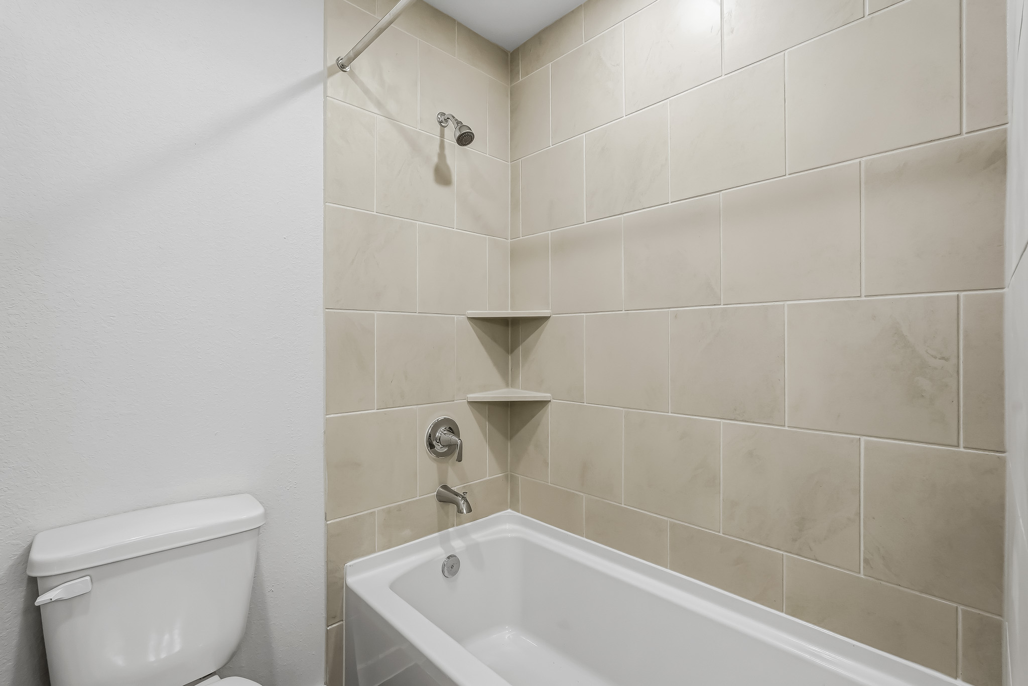 A bathroom with a bathtub and toilet.