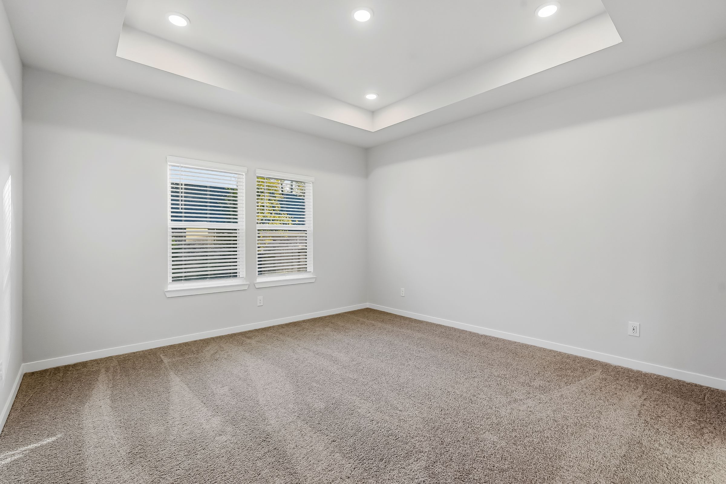 A room with a carpet and a window.