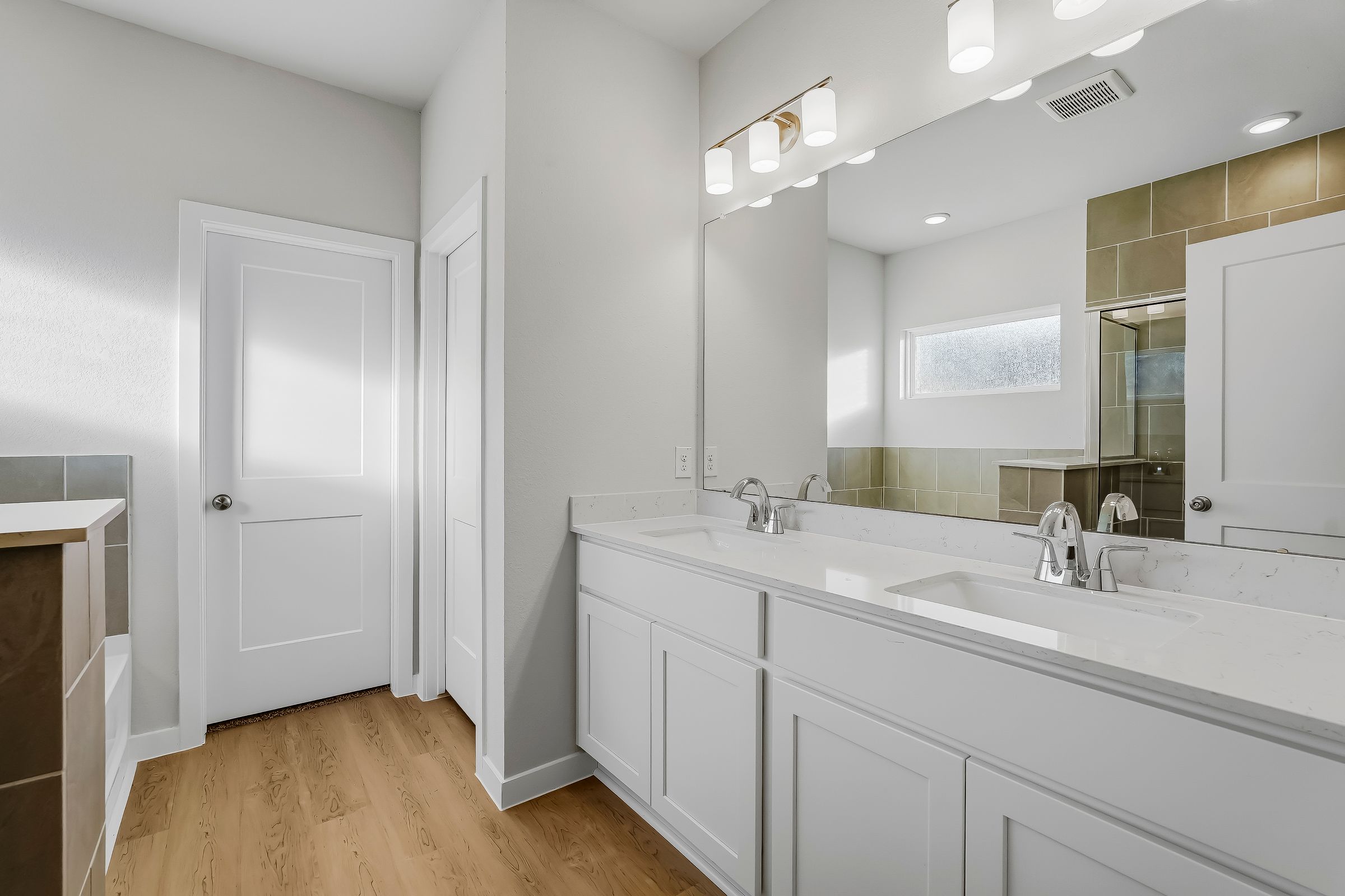 A bathroom with white cabinets.