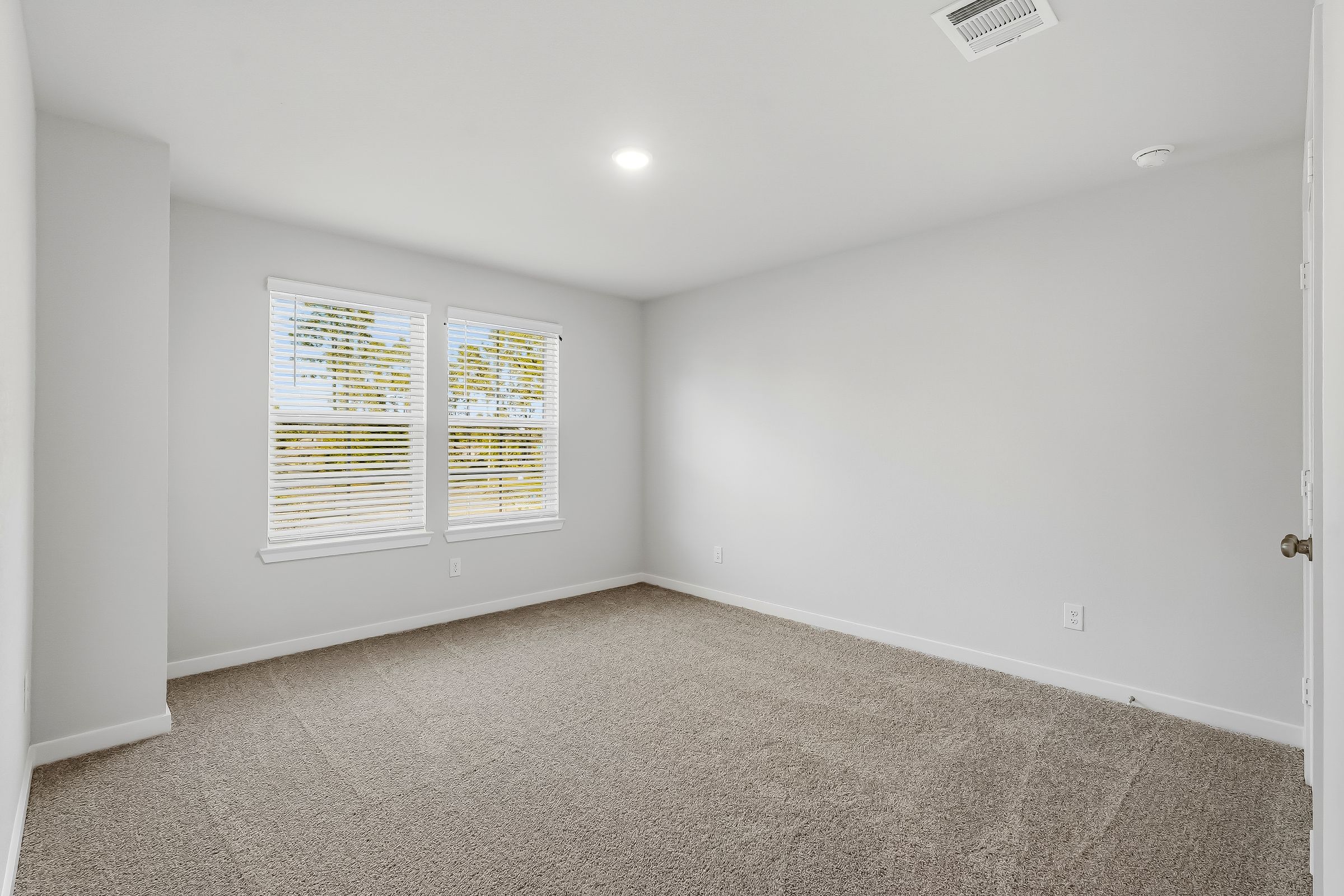 A room with a carpet and a window.