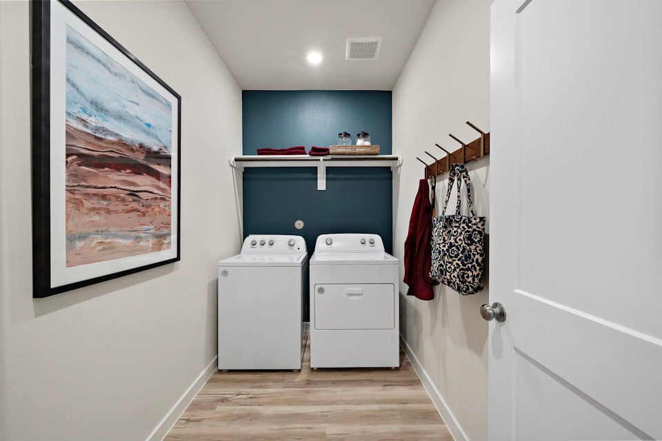 A room with a white cabinet and a white wall with a picture on it.