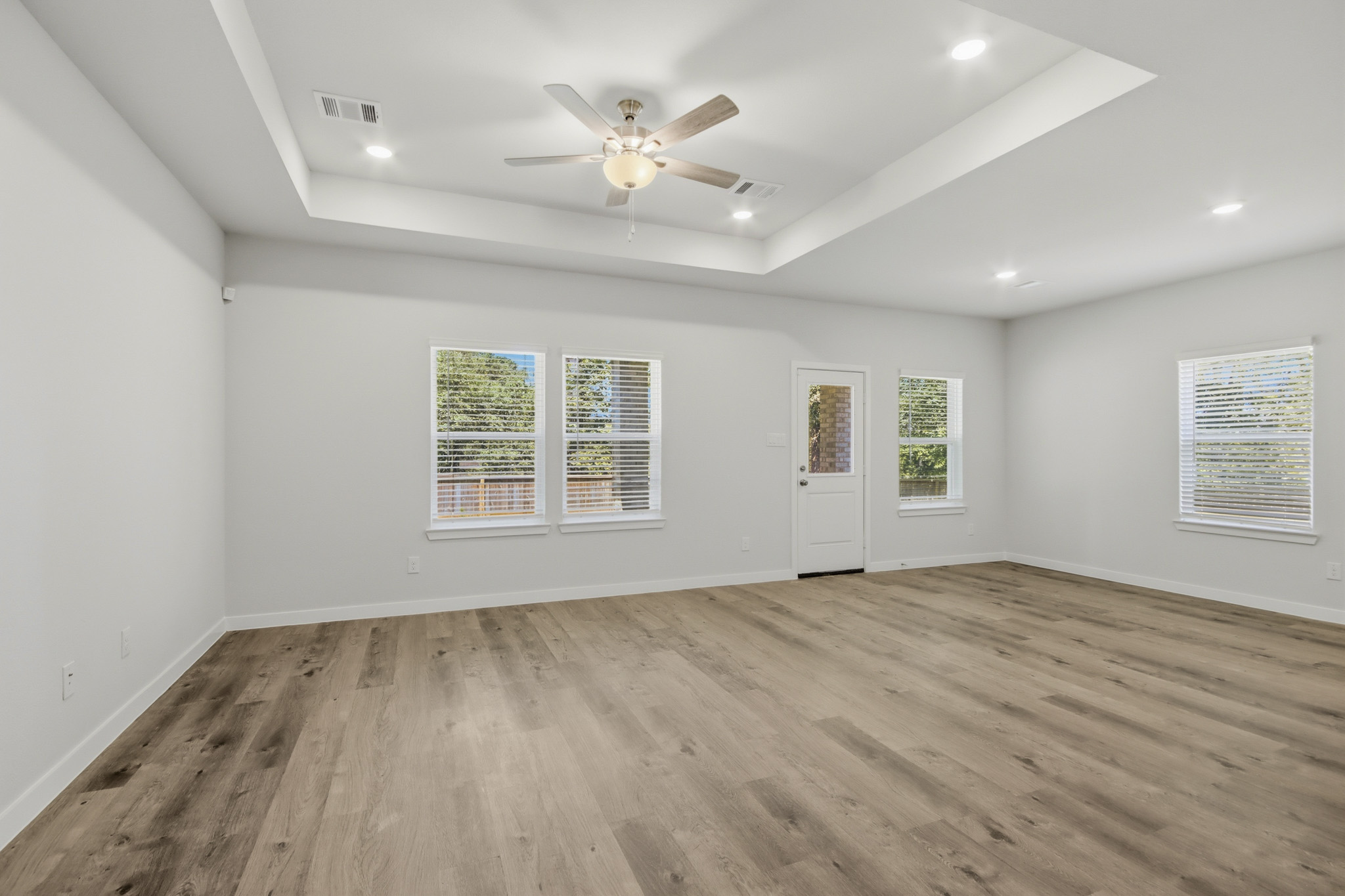 A room with a wood floor and a ceiling fan.