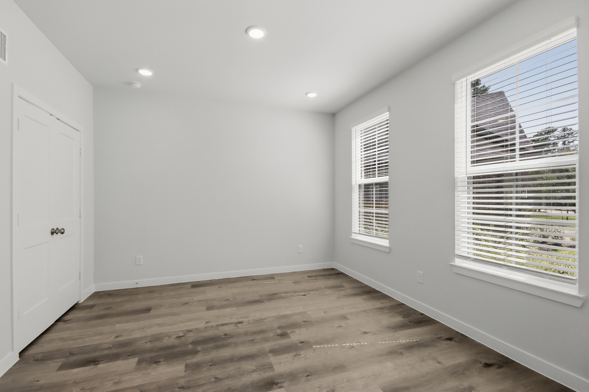 A room with a wood floor and white walls.