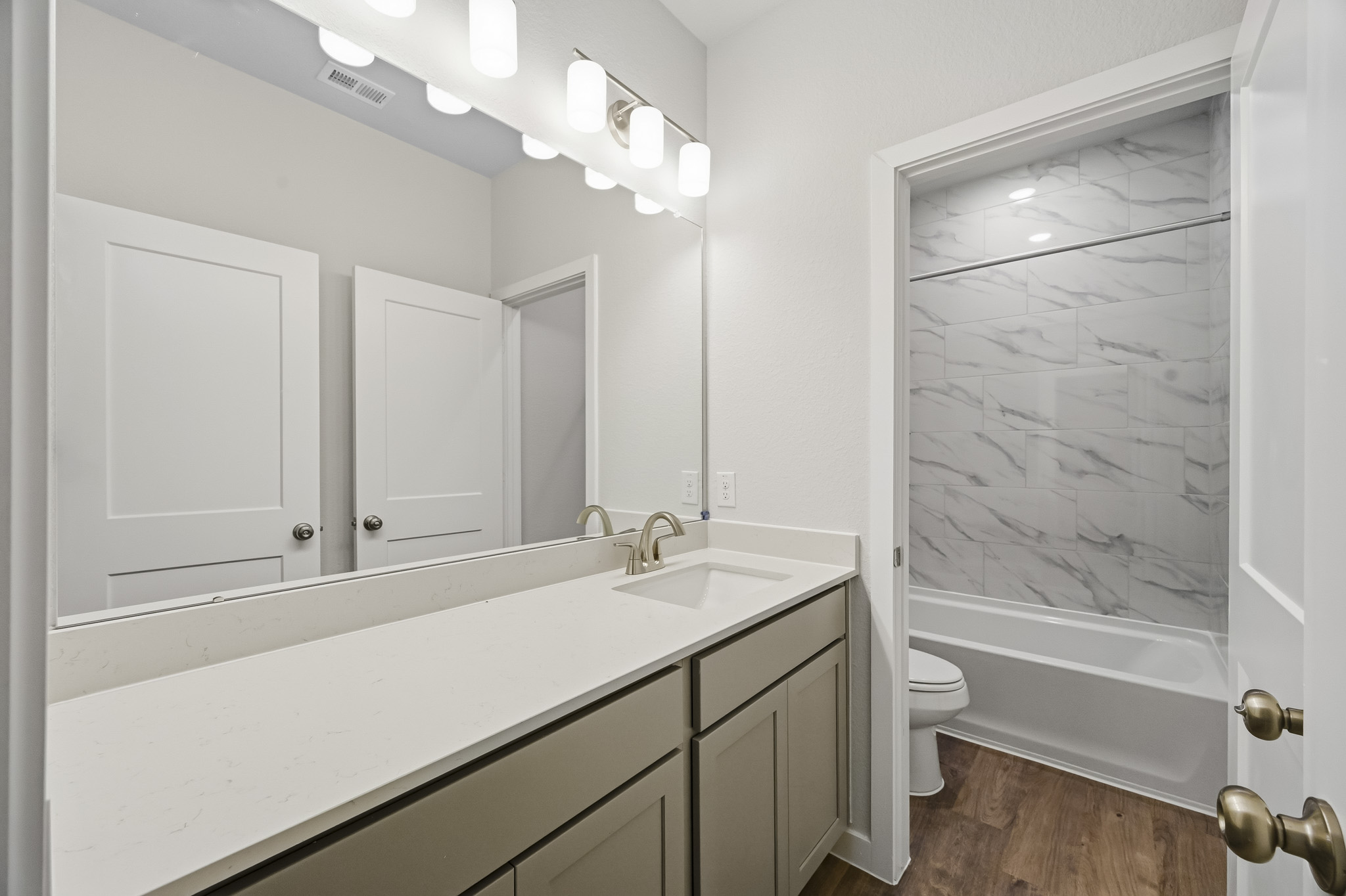 A bathroom with a sink and a shower unit.