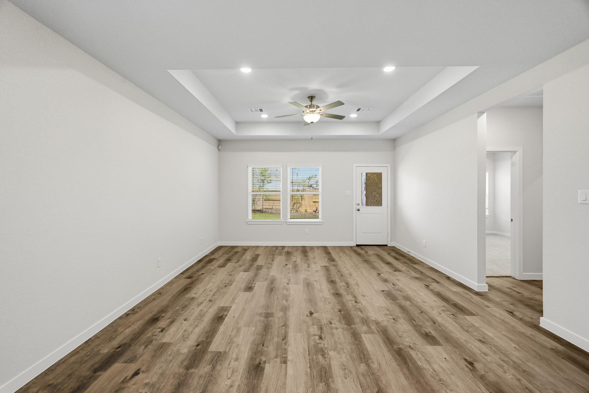 A room with a wood floor and a ceiling fan.