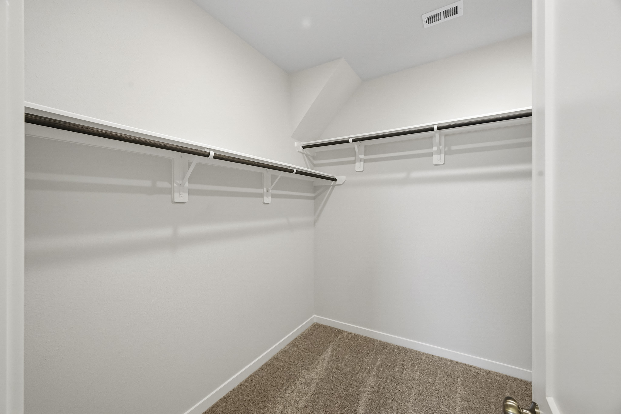 A white hallway with a metal railing.