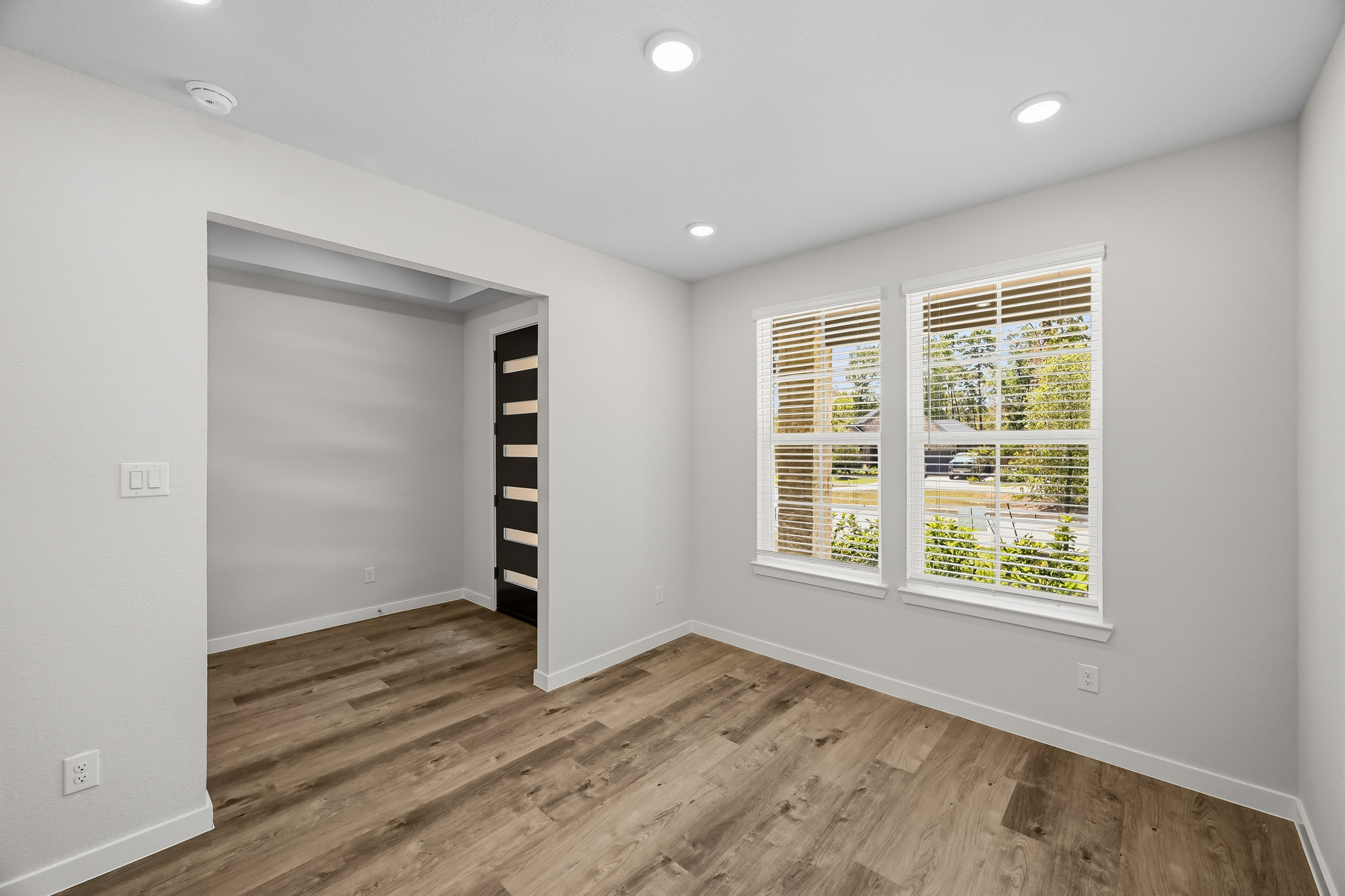 A room with a wood floor and a window.