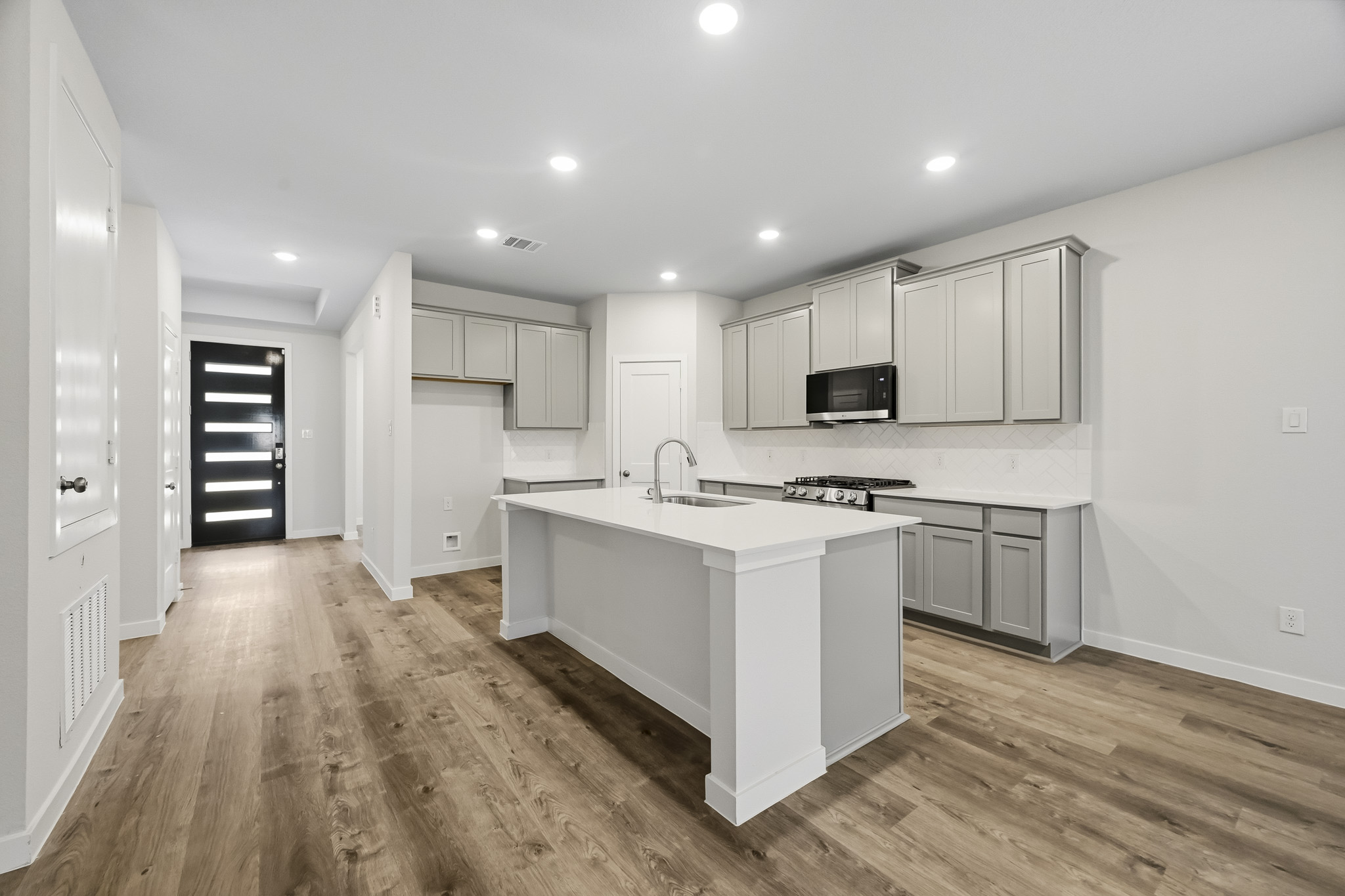 A kitchen with white cabinets.