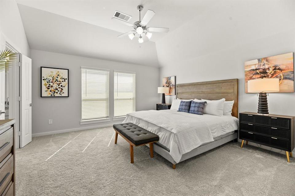 A bedroom with a bed and a fan.