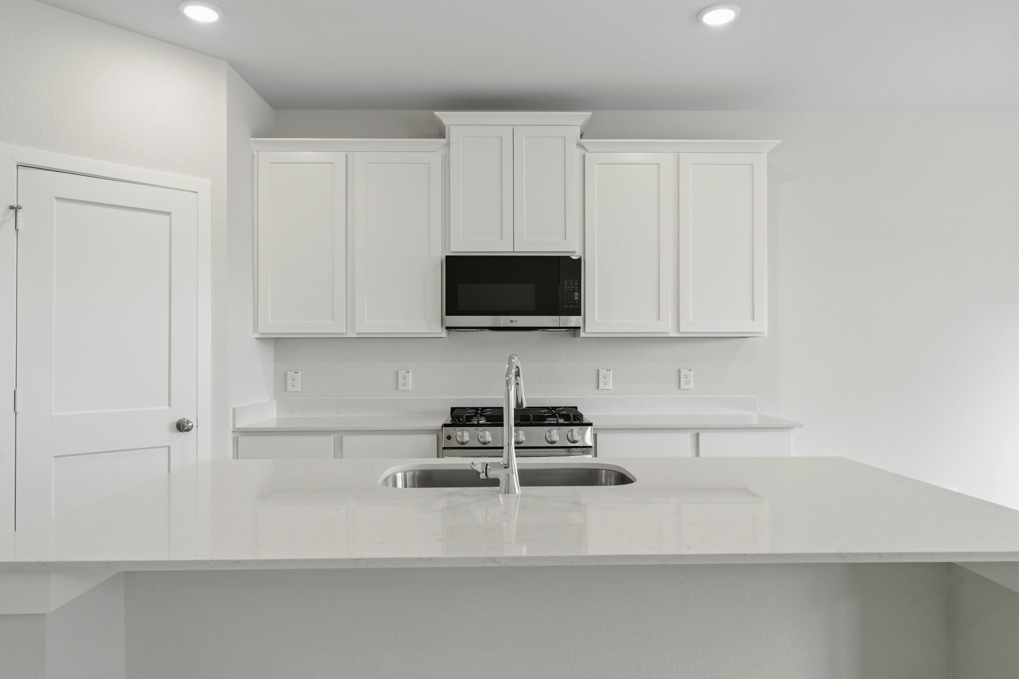 A kitchen with white cabinets.