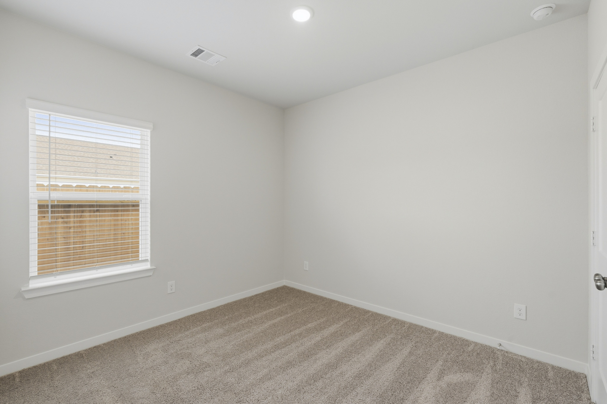 A room with a carpet and a window.