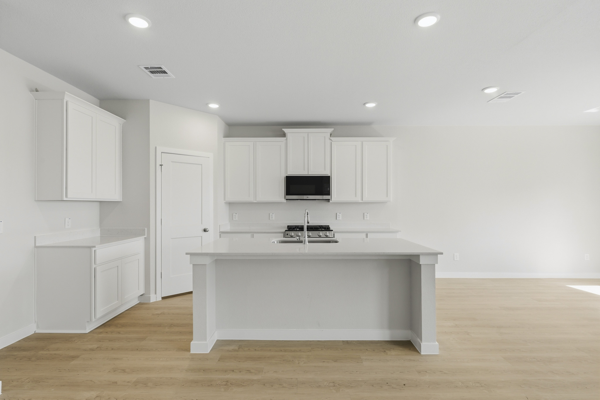 A kitchen with white cabinets.