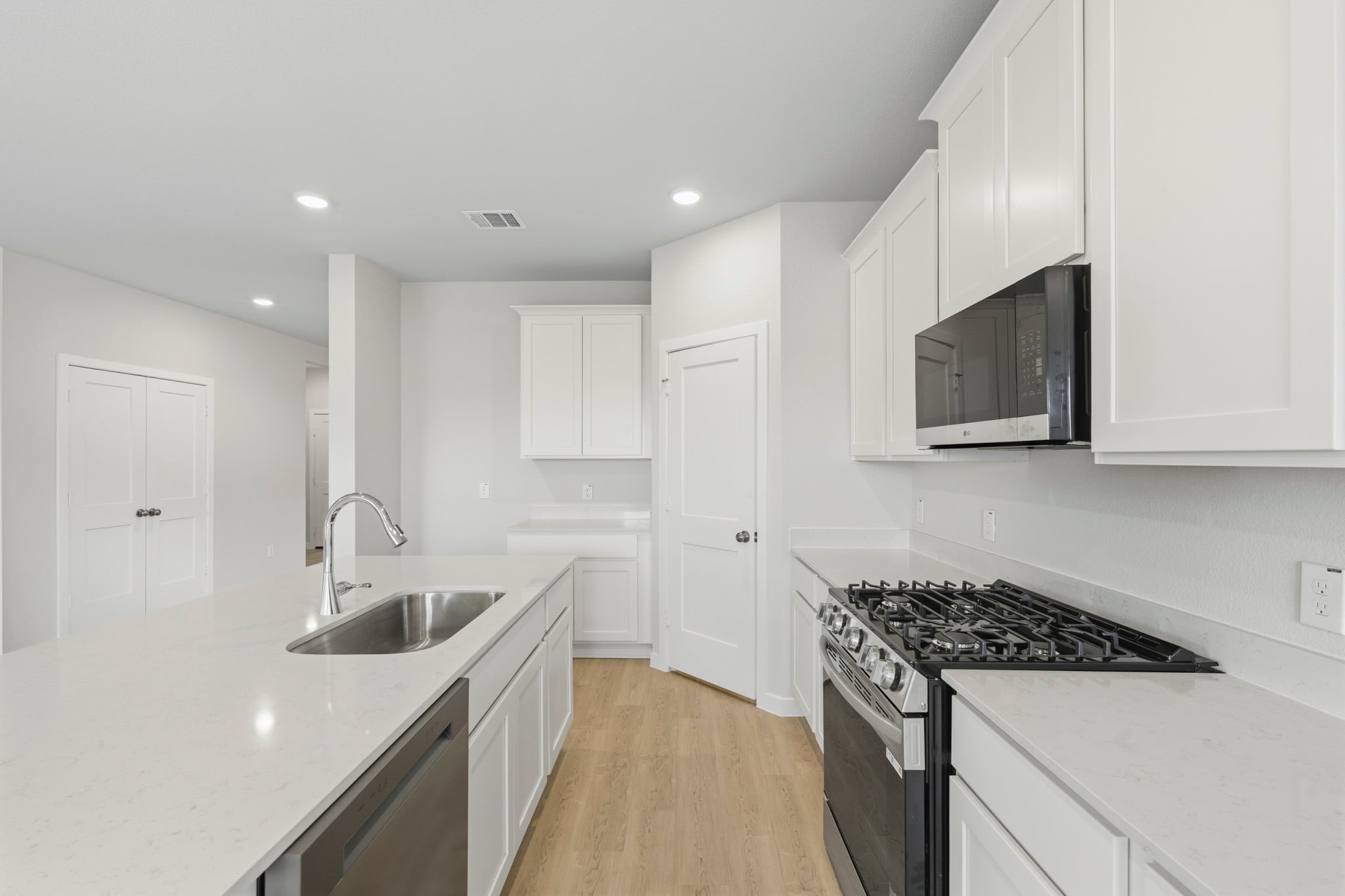 A kitchen with white cabinets.
