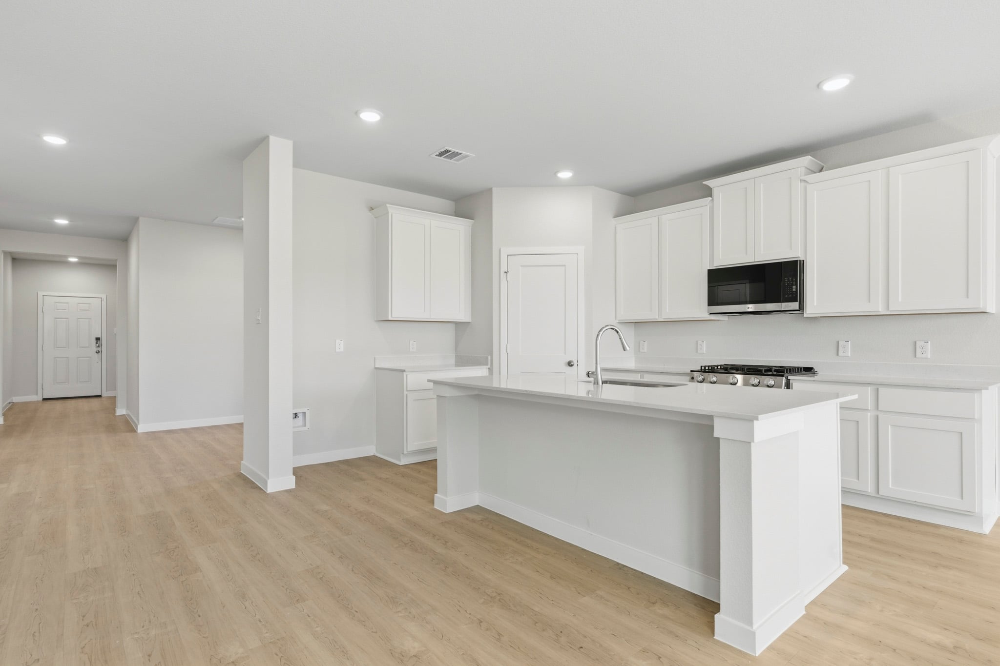 A kitchen with white cabinets.