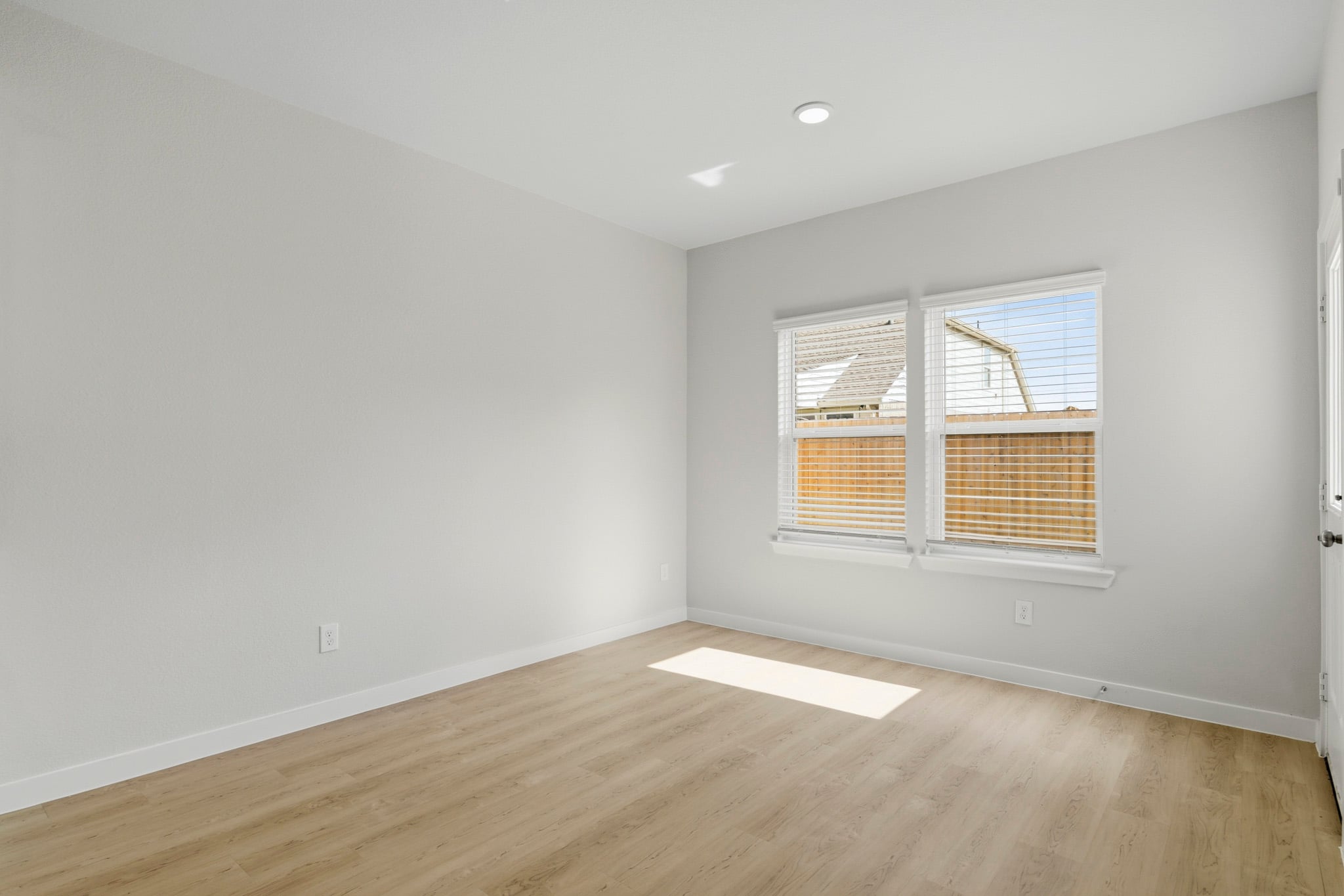 A room with a wood floor and a window.