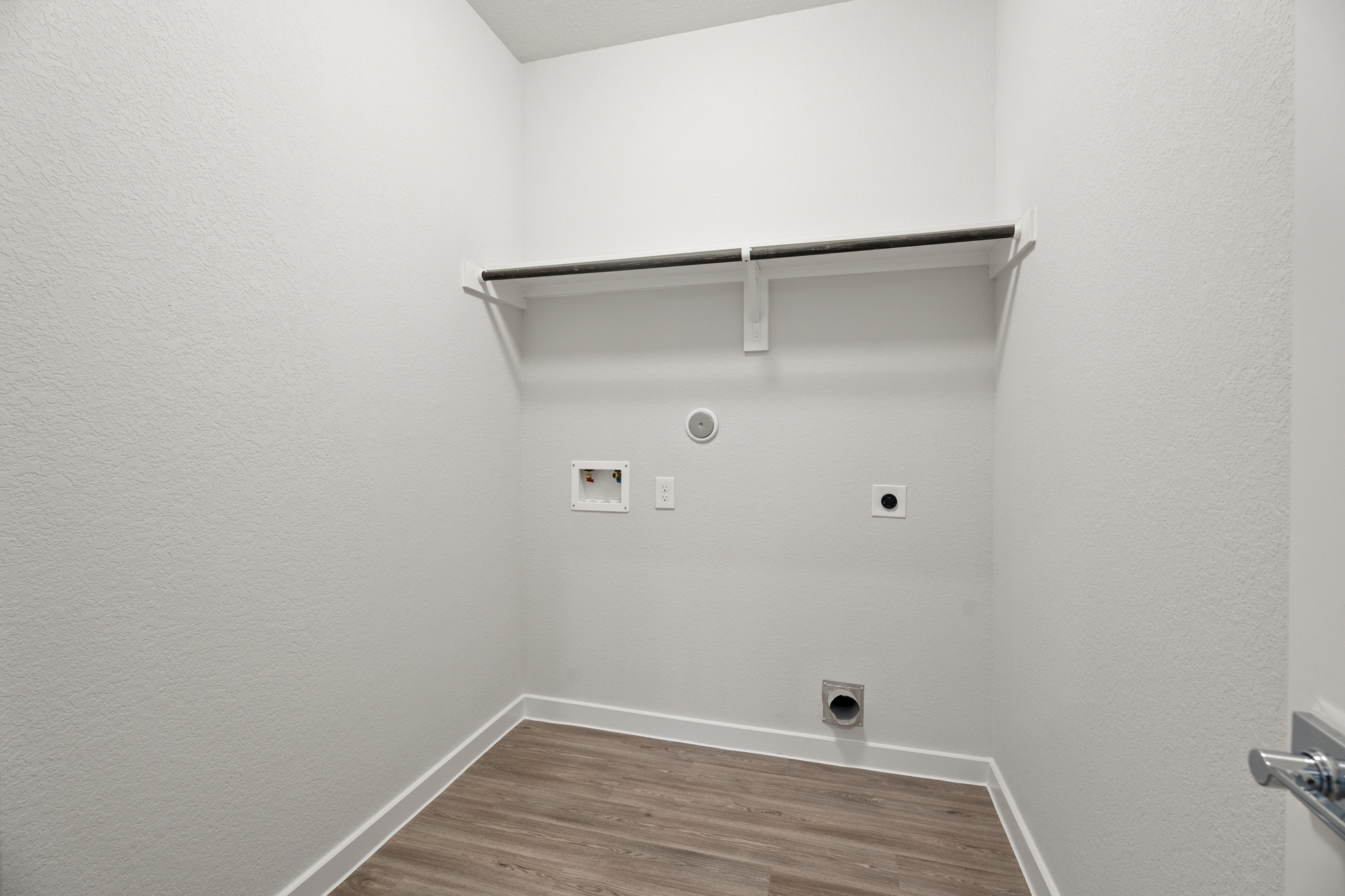A white wall with a metal bar.