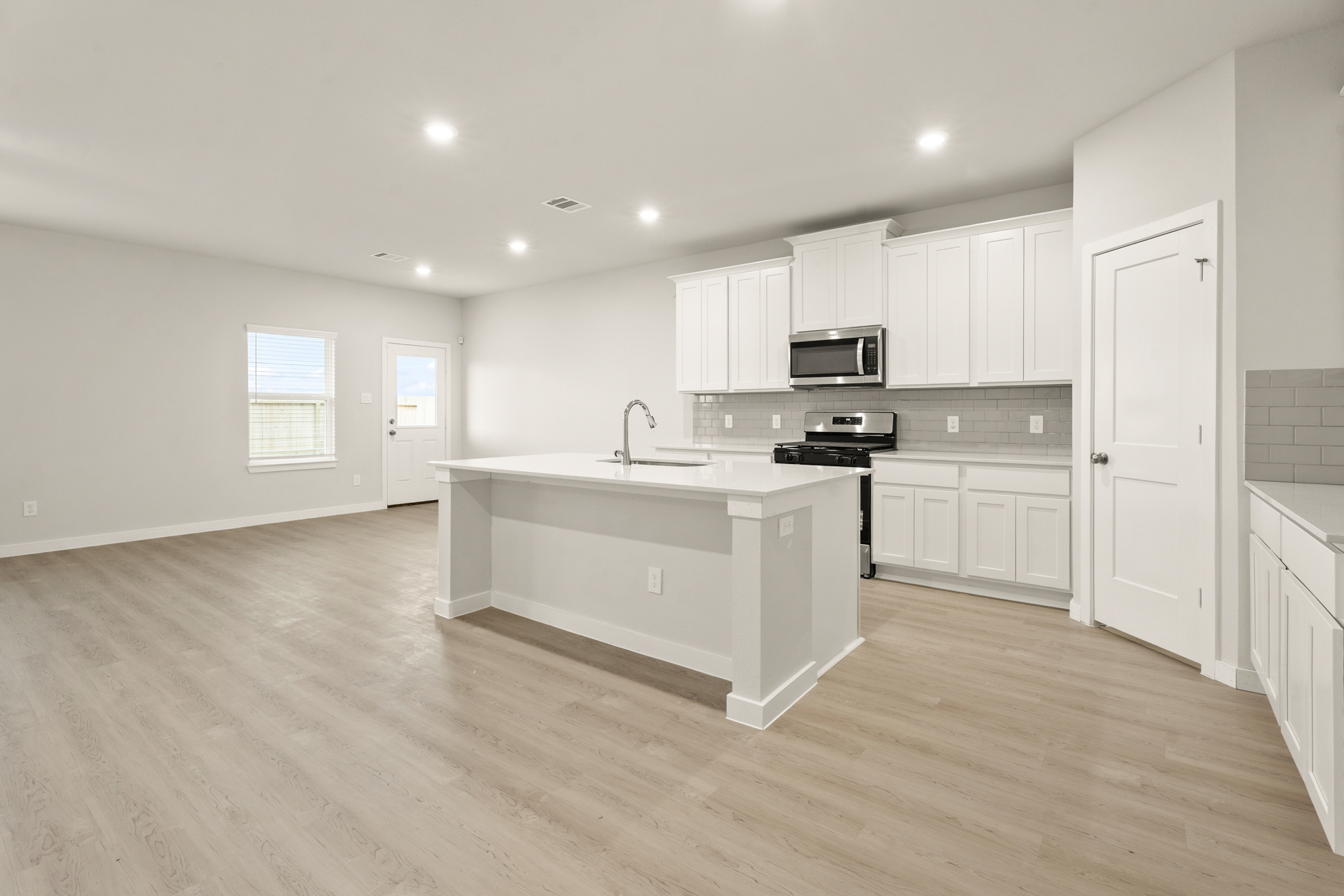 A kitchen with white cabinets.