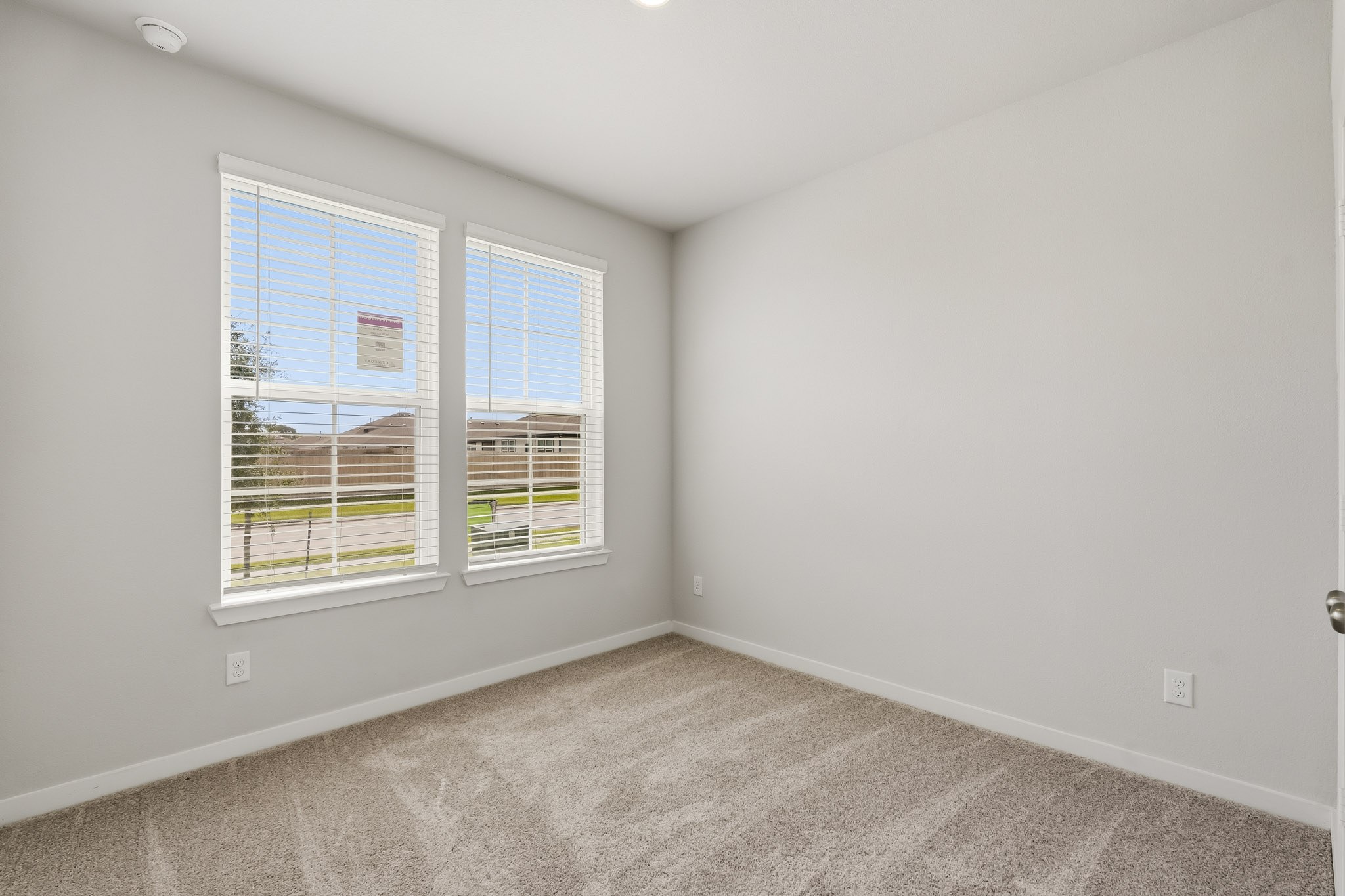 A room with a window and a carpet.