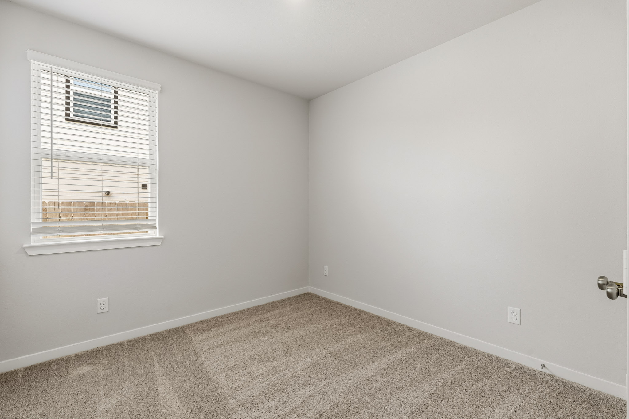 A room with a window and a carpet.