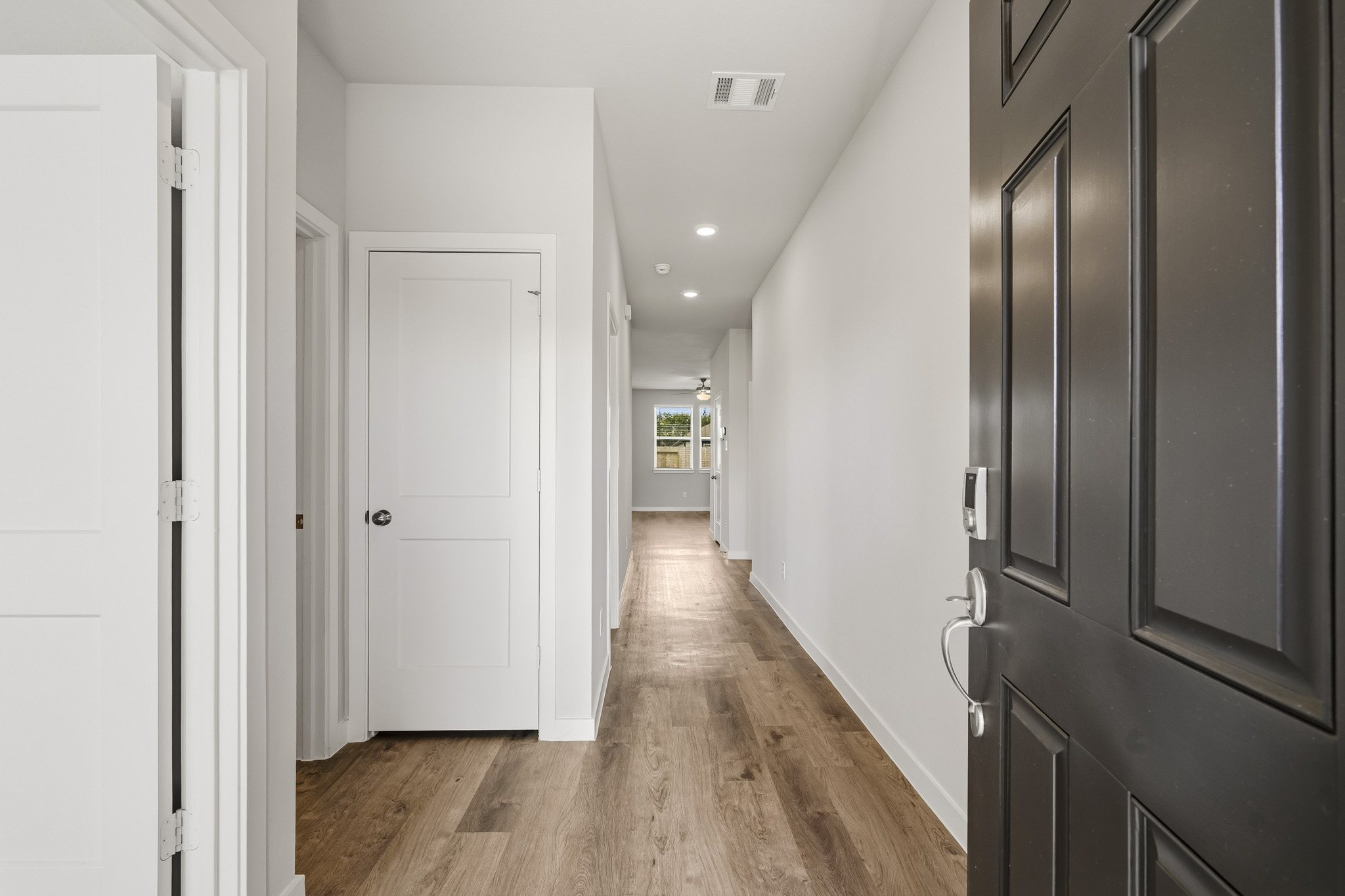 A hallway with black cabinets.