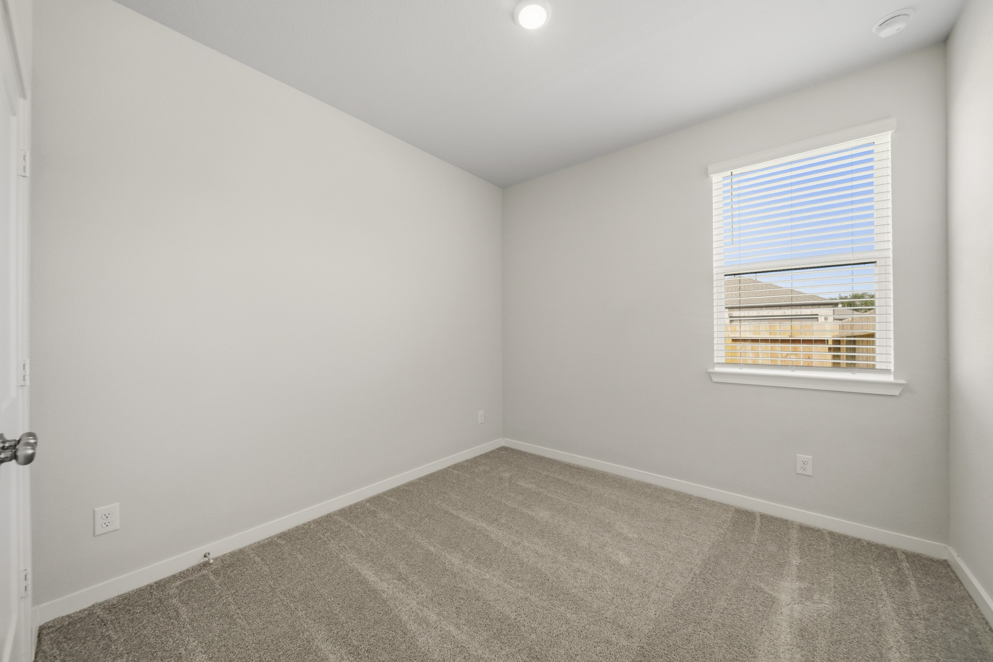 A room with a window and a carpet.