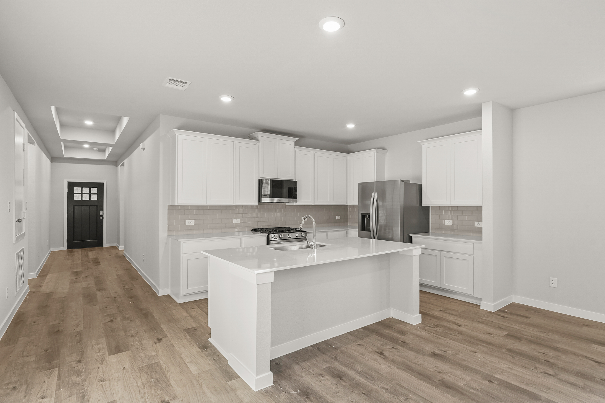 A kitchen with white cabinets.