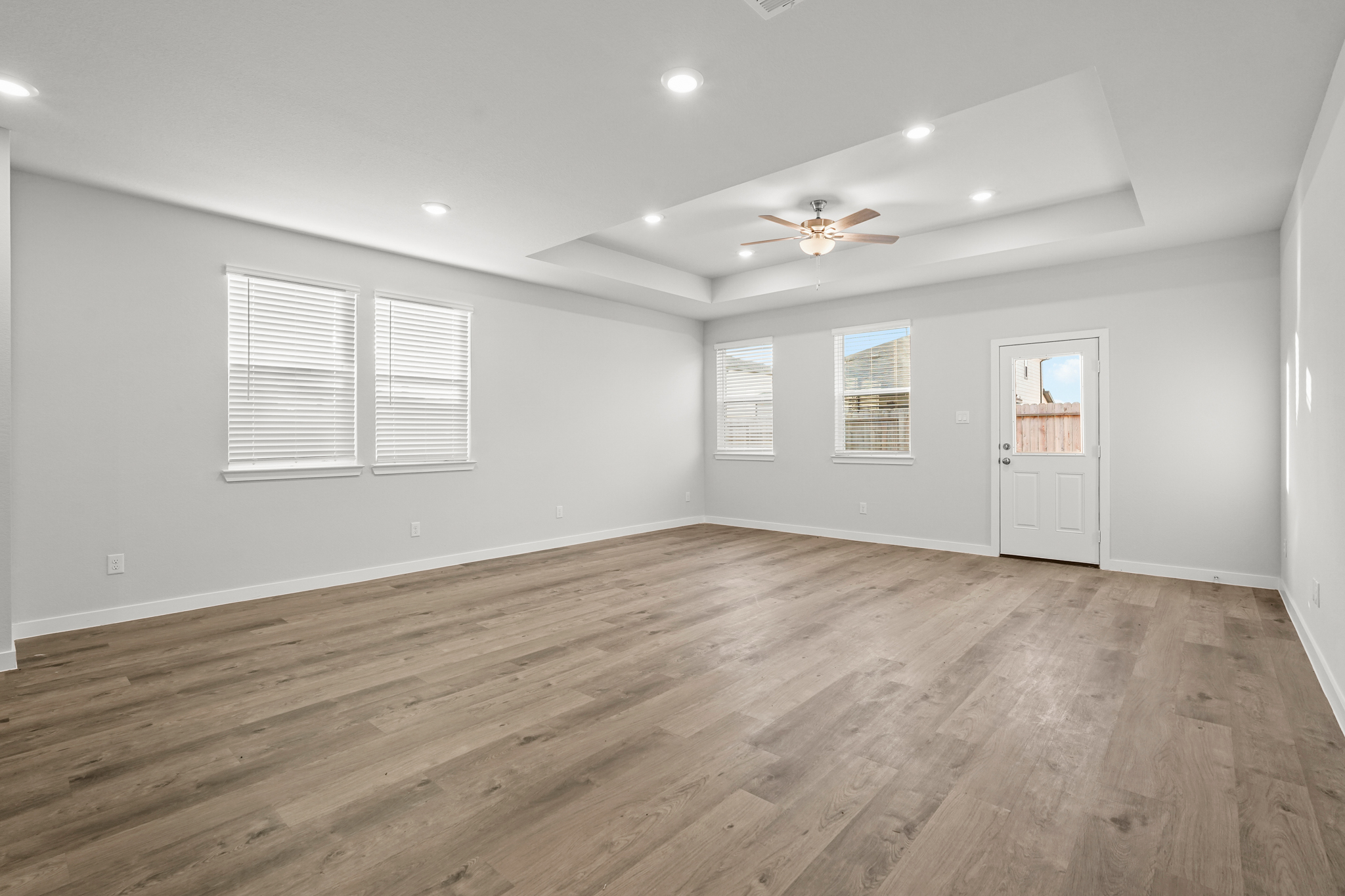 A room with a wood floor and a ceiling fan.