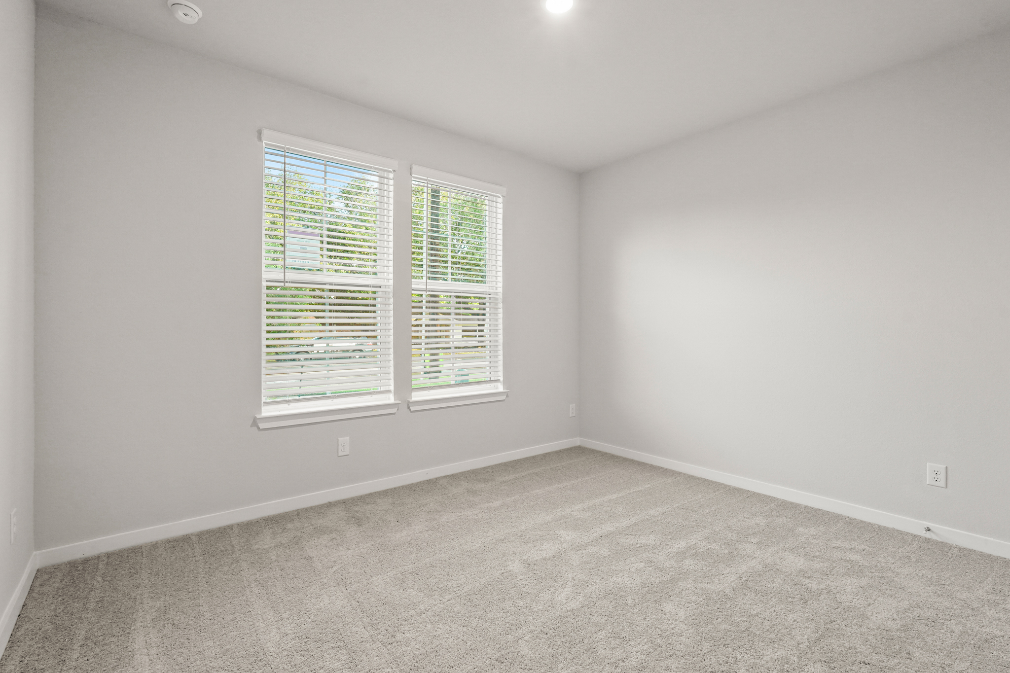 A room with a window and a carpet.