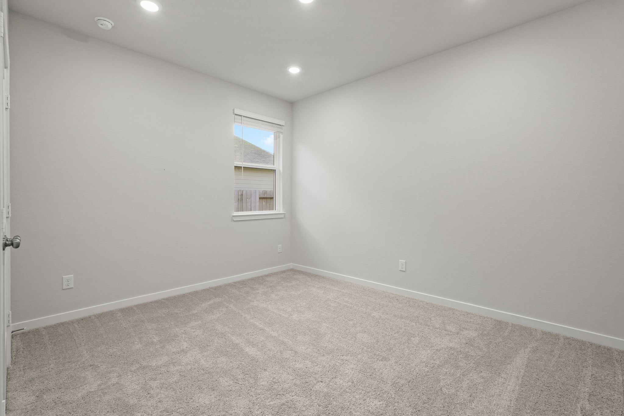 A room with a window and a carpet.