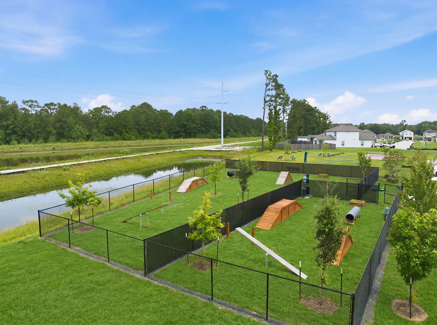 A large green field with a pond.