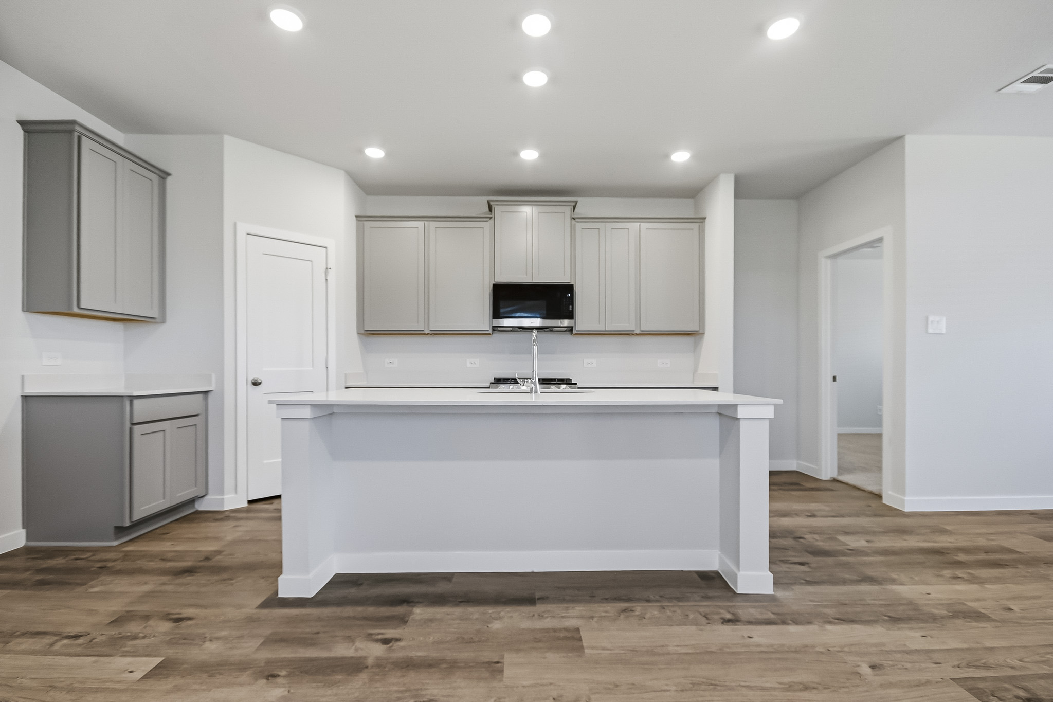 A kitchen with white cabinets.