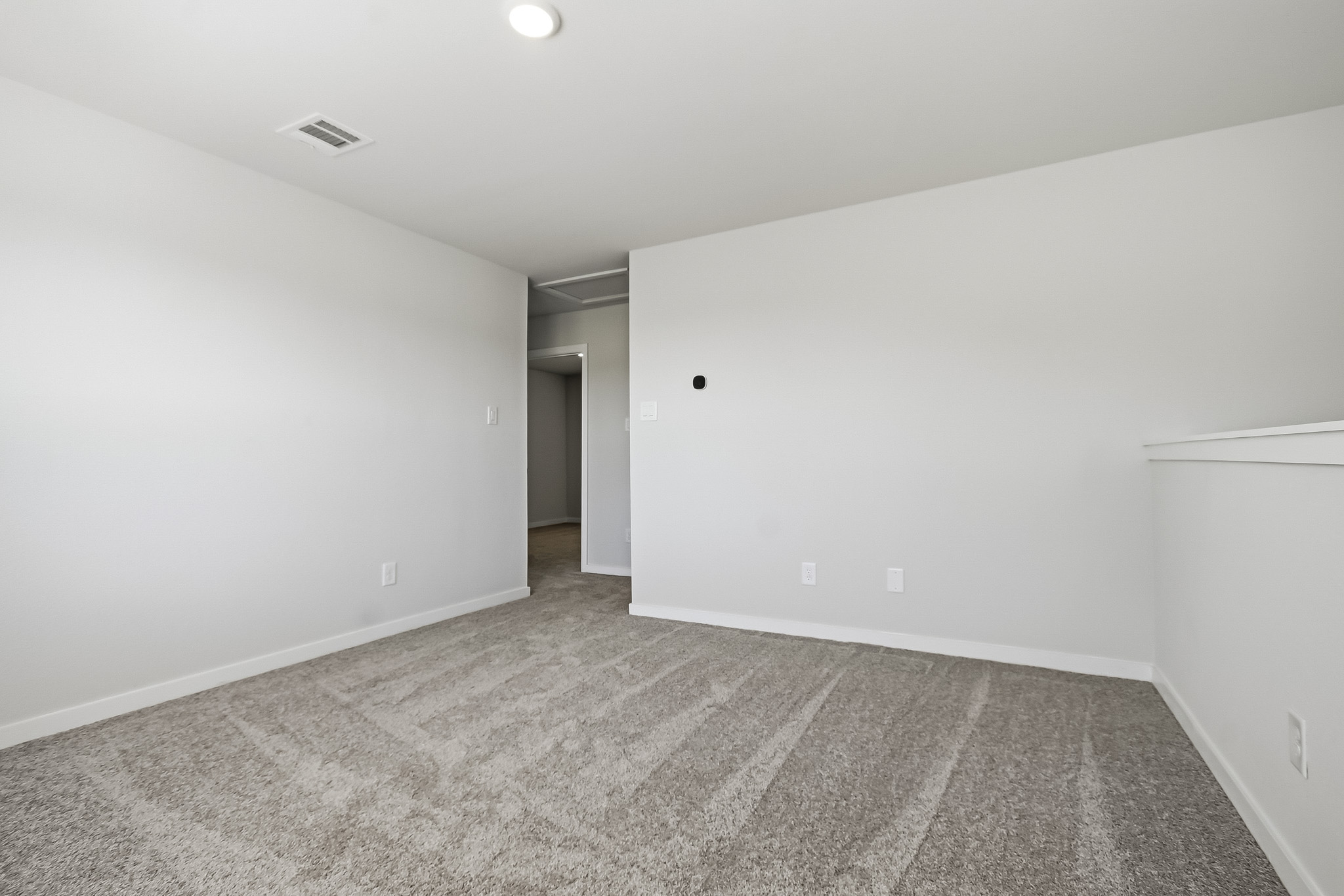 A room with a carpet and a door.
