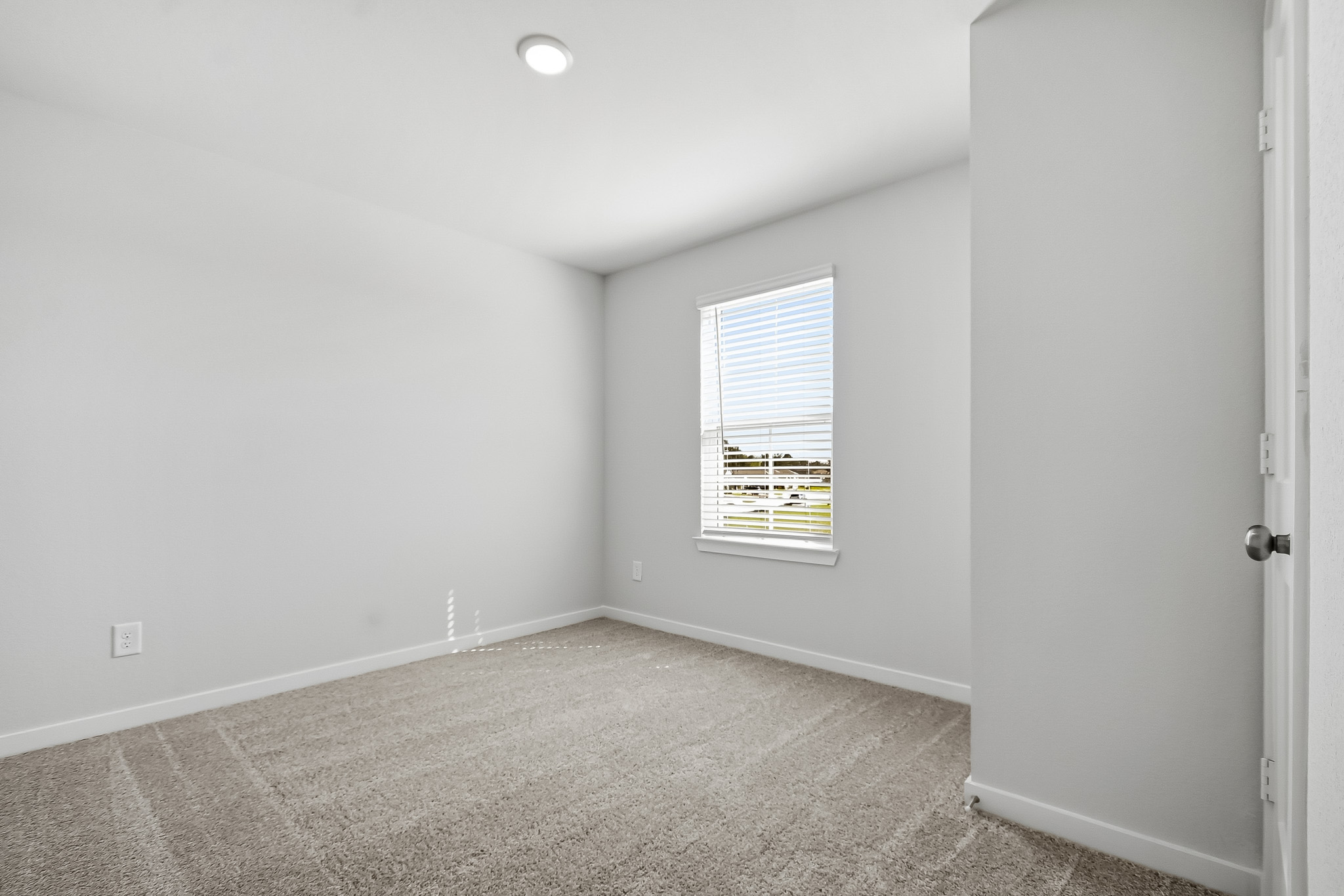 A room with a carpet and a window.