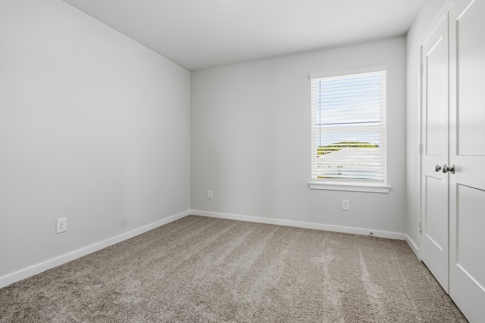 A room with white walls and a carpet.