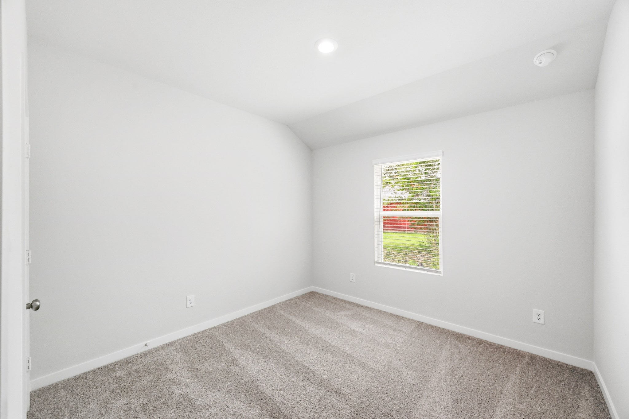 A room with a window and carpet.