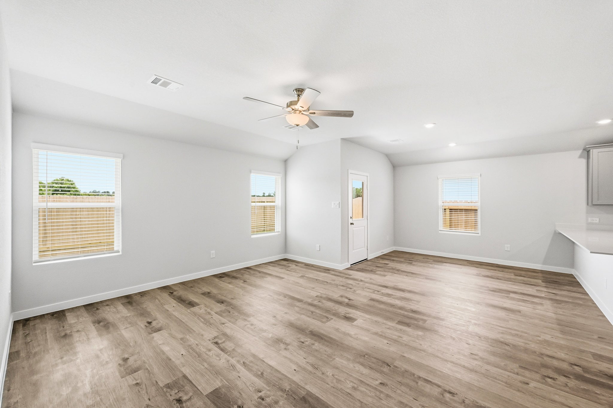 A room with a wood floor and a ceiling fan.