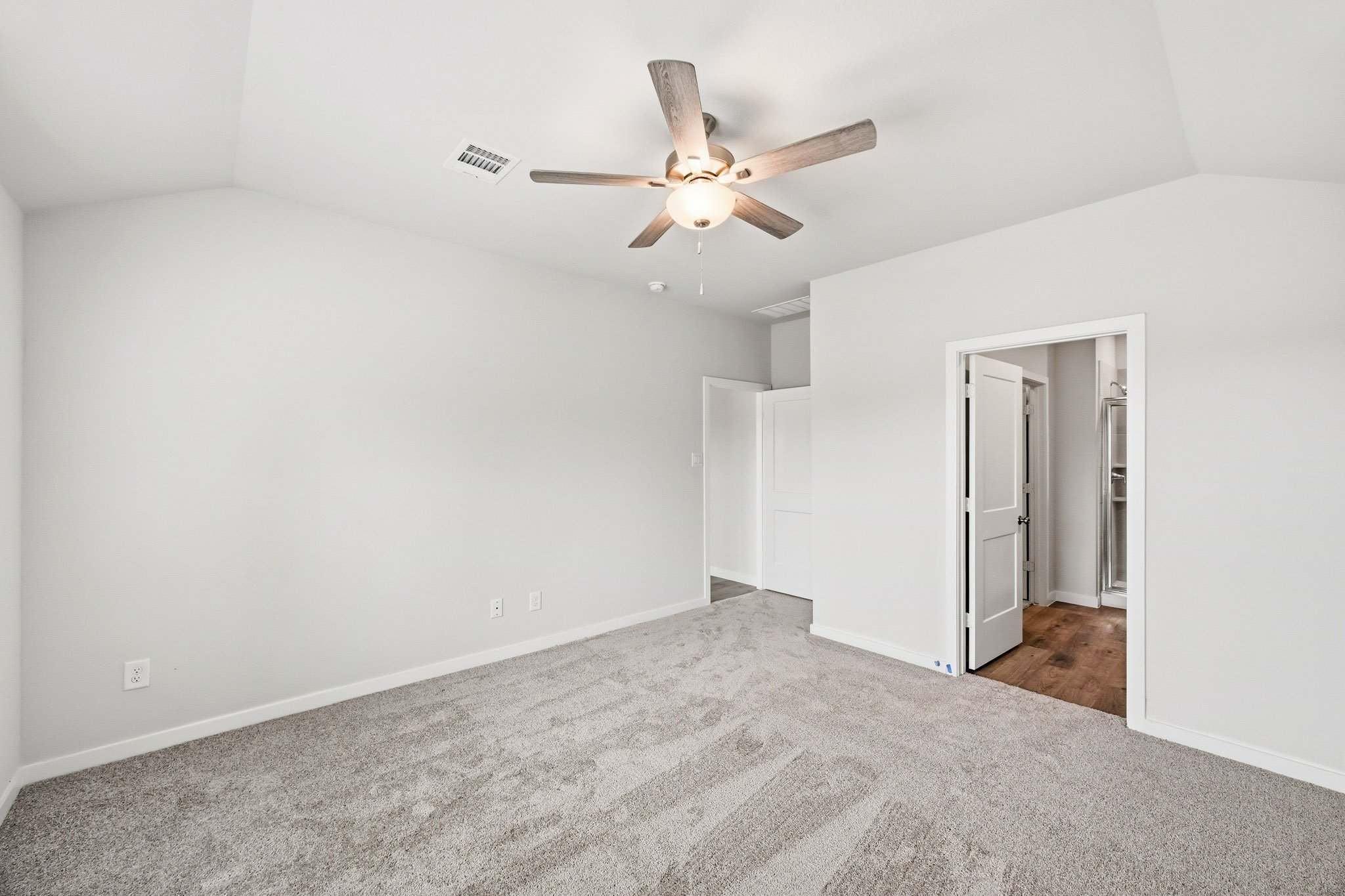 A room with a ceiling fan and a door.