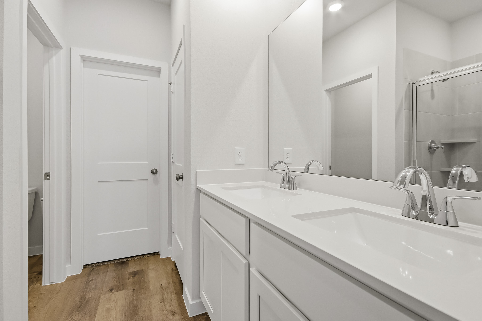 A bathroom with white cabinets.