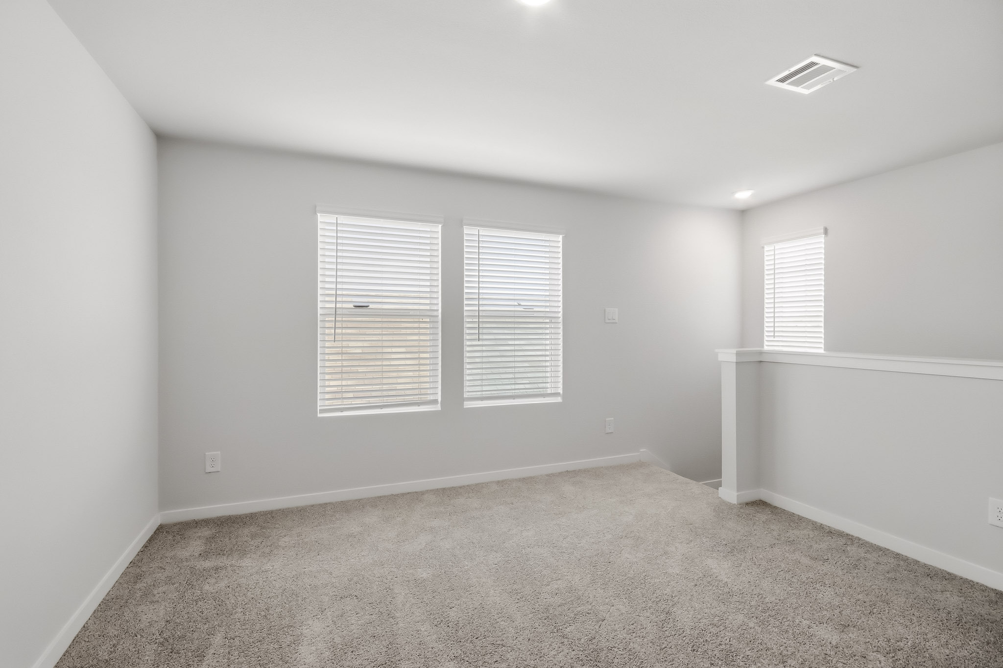 A room with a carpet and windows.