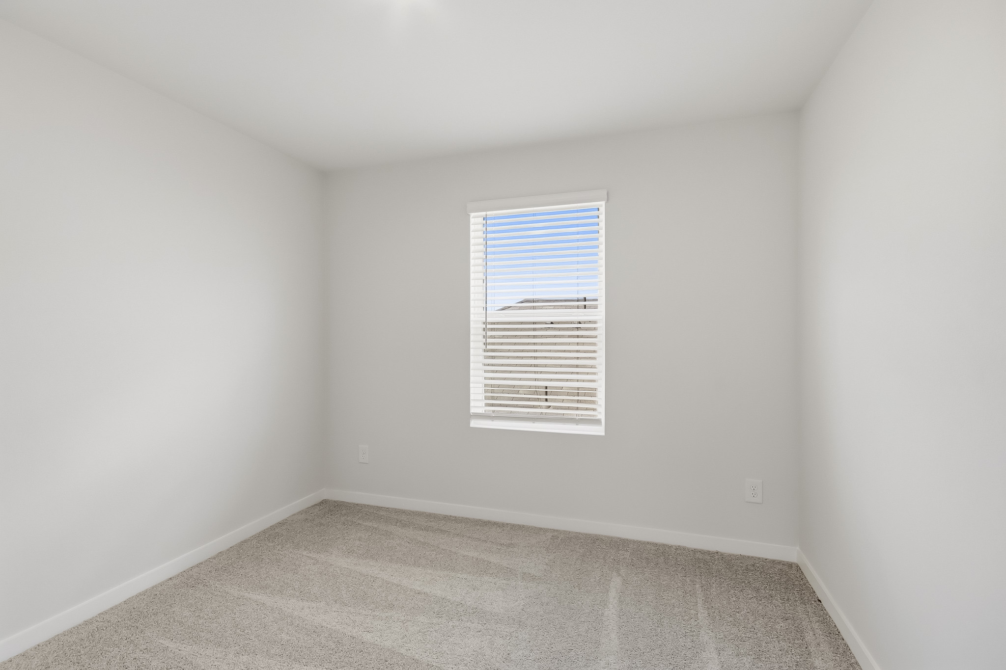 A room with a window and a carpet.