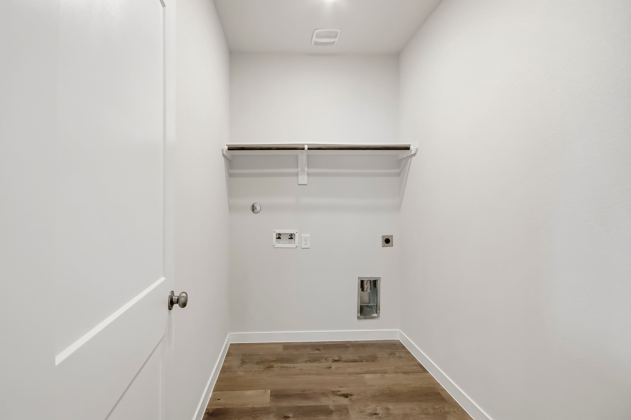 A white room with a wood floor.