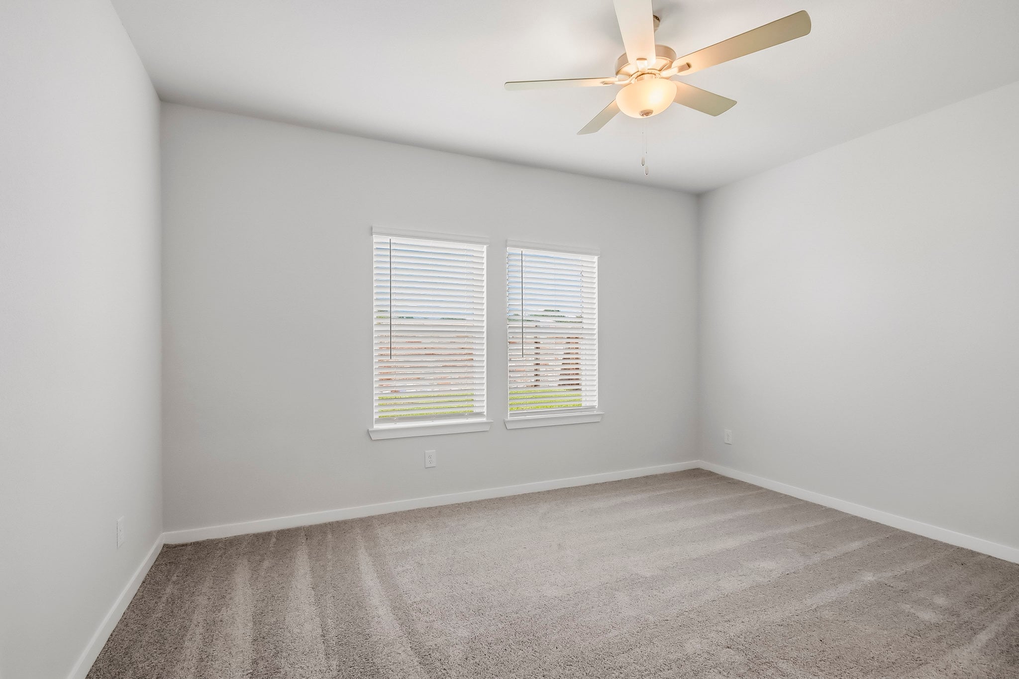 A room with a ceiling fan and a window.
