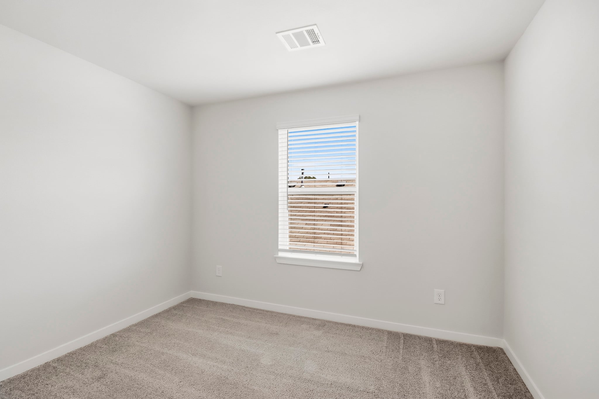 A room with a window and a carpet.