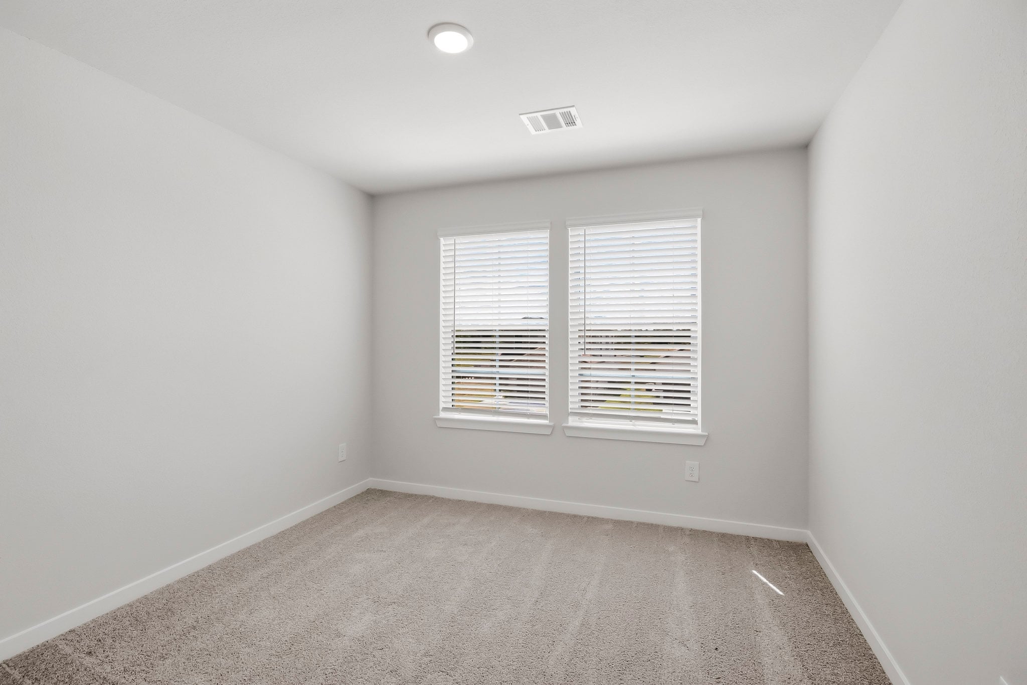 A room with a window and a carpet.