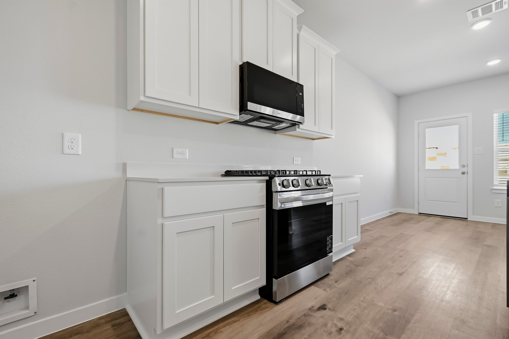 A kitchen with white cabinets.